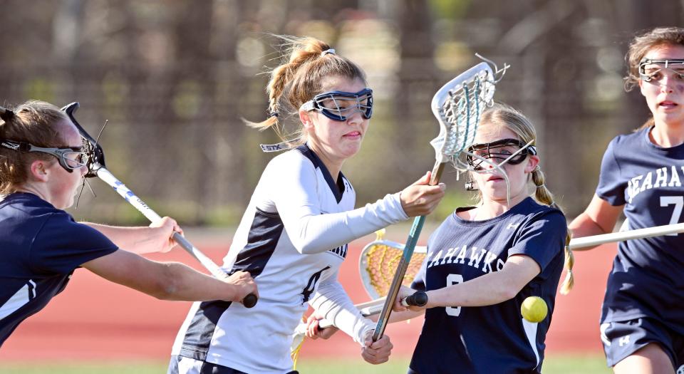 Emily Layton of Monomoy loses the ball pressured by Quinn Powers (center), Mavis O'Neil (left) and Ella Bartolomei of Cape Cod Academy in this May 10 game in Harwich.