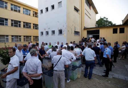 Election workers carry ballot boxes to a local election counting centre in Shkodra