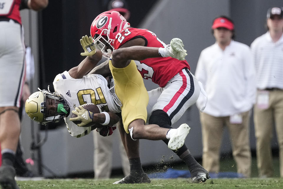 Georgia Tech wide receiver Malik Rutherford (12) is brought down by Georgia defensive back Tykee Smith (23) after a catch during the first half of an NCAA college football game Saturday, Nov. 26, 2022 in Athens, Ga. (AP Photo/John Bazemore)