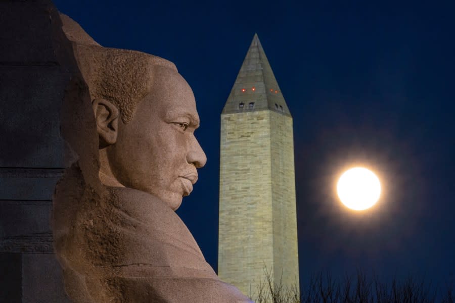 The rising full moon passes behind the Martin Luther King Memorial and the Washington Monument, Tuesday evening, Dec. 29, 2020, in Washington. (AP Photo/J. David Ake)