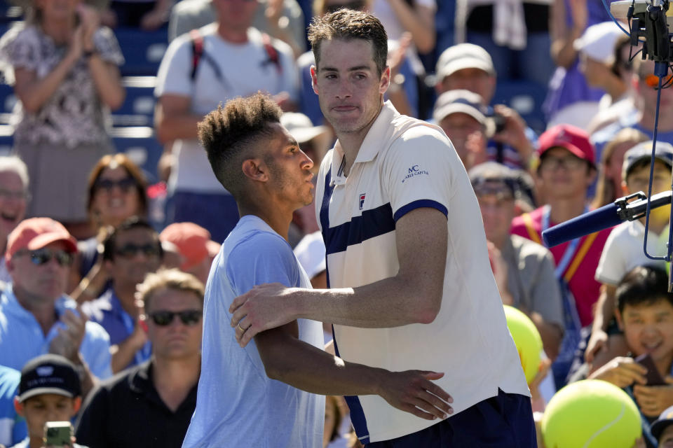 El estadounidense John Isner recibe el saludo de su compatriota Michael Mmoh tras la victoria de Mmoh en la segunda ronda del US Open, el jueves 31 de agosto de 2023, en Nueva York. (AP Foto/John Minchillo)