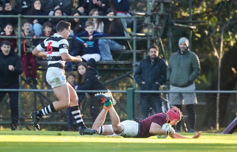 Juan Akemeier, del CASI, no logra evitar un try de Mateo Montoya, de Newman; el Cardenal batió al puntero del Top 12 de URBA y parece estar en vías de recuperación.