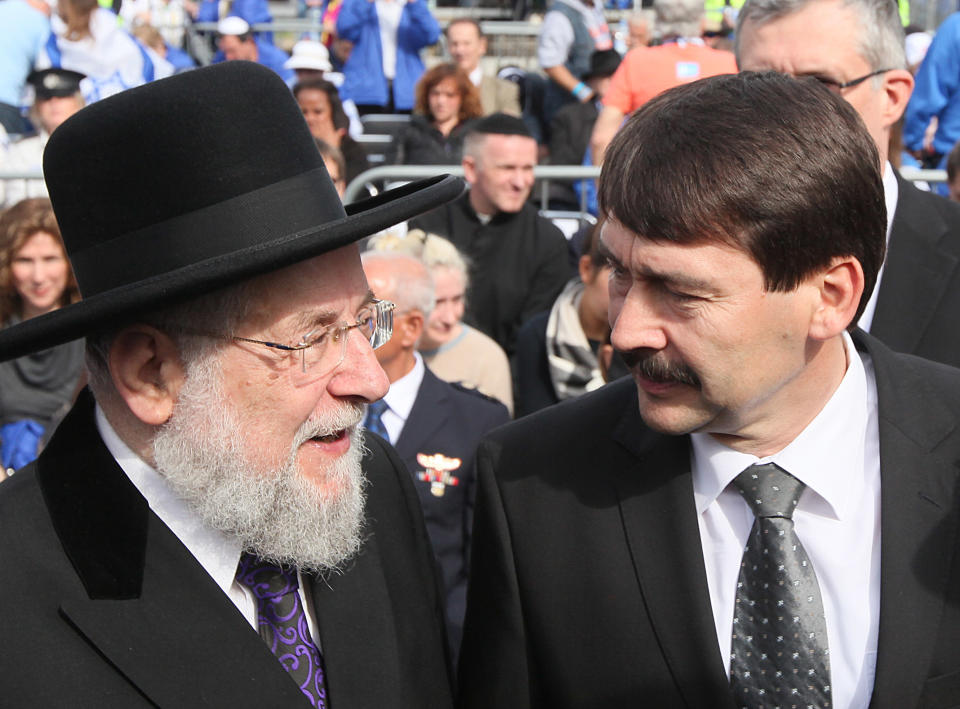 Former chief rabbi of Tel-Aviv, Israel Meir Lau, left, talks with Hungary’s President Janos Ader prior the ceremonies at the memorial to the 6 million Holocaust victims held in Oswiecim, Poland, on Monday, April 28, 2014. The observance is held during the annual march of the living by Jewish youths from around the world. This year the march honors also some 430,000 Hungarian Jews brought to the camp in 1933, most of them died in gas chambers. (AP Photo/Czarek Sokolowski)