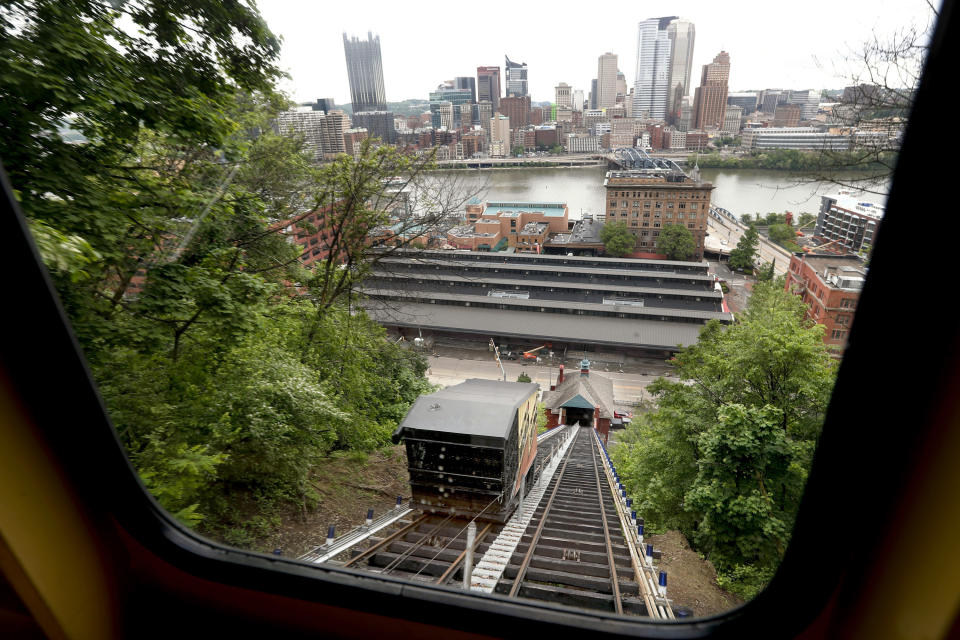 The skyline of the city of Pittsburgh is seen through a window in the Monongahela Incline as it approaches the passing car down the hill to the lower terminal on Friday, May 10, 2019, in Pittsburgh. The incline that transports people up and down the side of a hill in Pittsburgh reopened today after being closed since February. (AP Photo/Keith Srakocic)
