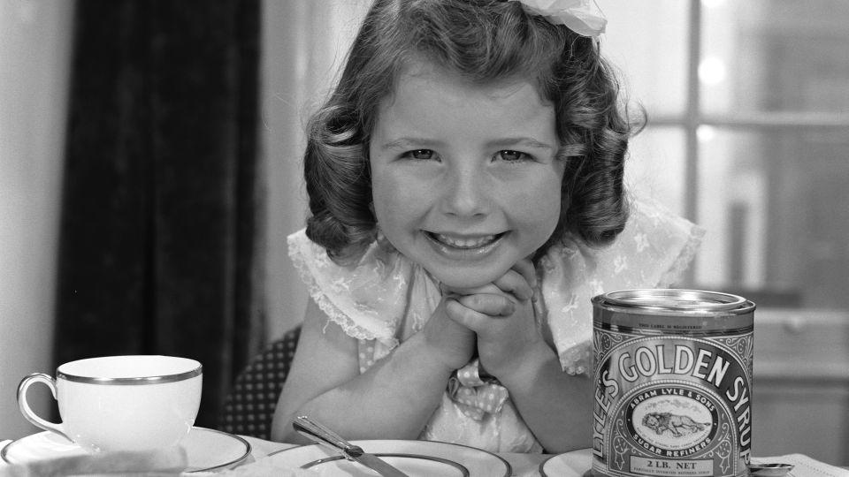 The product has been a staple in the pantries of British bakers since its inception. Above, a young girl about to spread the syrup on bread in 1957. - Jamie Hodgson/Hulton Archive/Getty Images