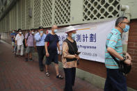 People wearing face masks queue for the coronavirus test outside a testing center in Hong Kong, Tuesday, Sept. 1, 2020. Hong Kong began a voluntary mass-testing program for coronavirus Tuesday as part of a strategy to break the chain of transmission in the city's third outbreak of the disease. The virus-testing program has become a flash point of political debate in Hong Kong, with many distrustful over resources and staff being provided by the China's central government and fears that the residents’ DNA could be collected during the exercise(AP Photo/Kin Cheung)