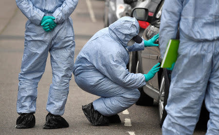 A forensic investigator examines a car on Chalgrove Road, where a teenage girl was murdered, in Tottenham, Britain, April 3, 2018. REUTERS/Toby Melville