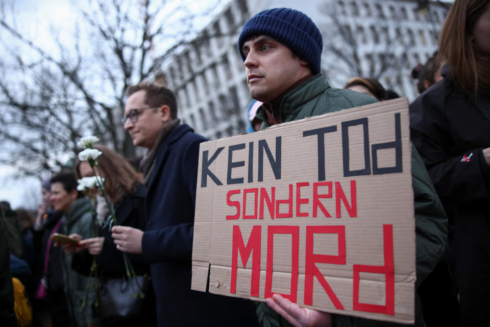 德國一名男子16日在柏林俄羅斯大使館前舉行的納瓦尼逝世守夜活動上，舉著寫有「不是死亡，而是謀殺」的標語牌。（路透社）