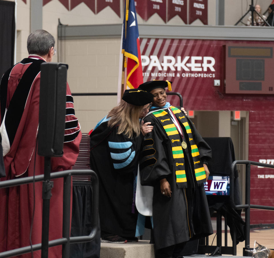 A Doctor of Education graduate leans back as her stole is placed upon her at the WT commencement ceremony Saturday morning at the First United Bank Center in Canyon.