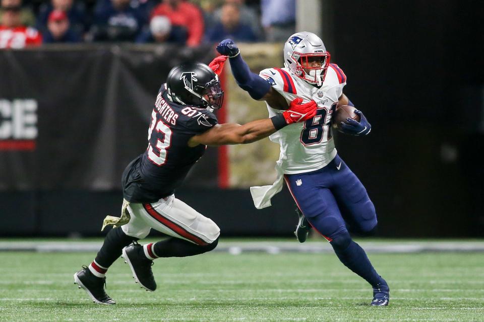 New England Patriots tight end Jonnu Smith breaks the tackle of Atlanta Falcons linebacker James Vaughters on Nov. 18, 2021, at Mercedes-Benz Stadium in Atlanta.