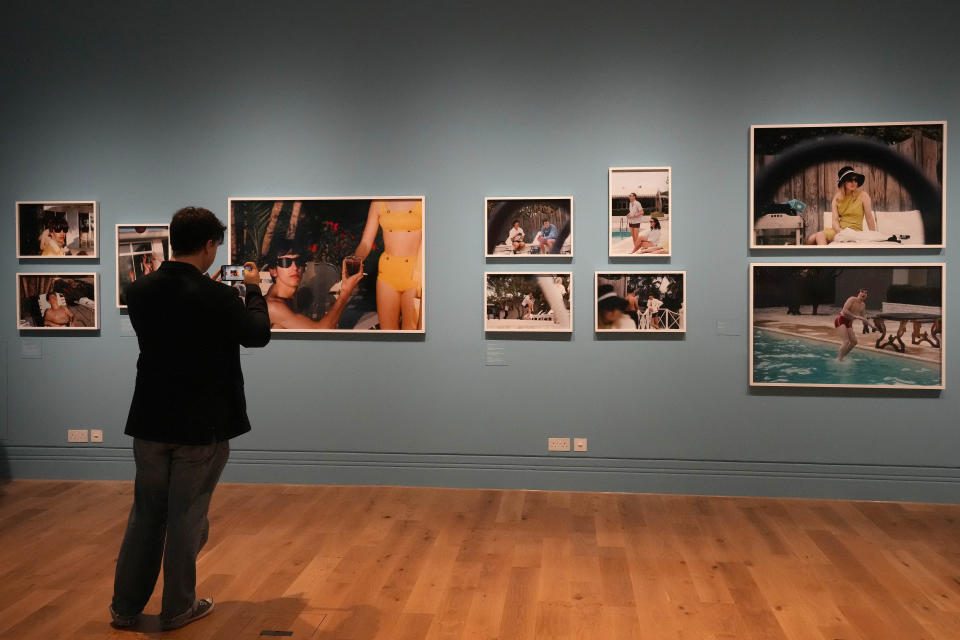 A visitor looks at pictures during a preview of Paul McCartney Photographs 1963-64: Eyes of the Storm exhibition at the National Portrait Gallery in London, Britain, Tuesday, June 27, 2023. The exhibition consists of unseen photographs taken by Paul McCartney from the Beatles at the height of Beatlemania. The gallery will open it's doors from June 28, 2023 until October 1, 2023. (AP Photo/Frank Augstein)