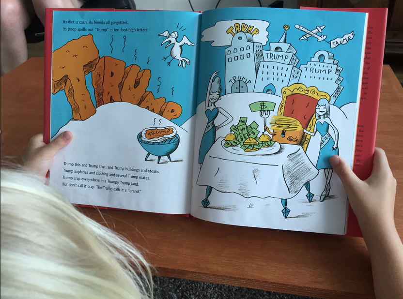 Una niña lee “A Child’s First Book of Trump”, con texto de Ian Black e ilustraciones de Mare Rosenthal. (Foto: AFP)