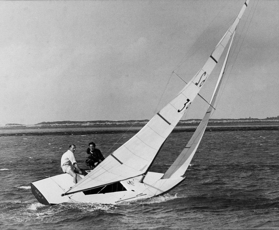 FILE - In this April 25, 1959 file photo, Britain's Prince Philip mans the tiller of the star class sailboat Gem IV, with Durward Knowles, right, as crew. After following the race Prince Philip made the cup presentation of the King's cup at the Nassau Yacht Club in Md. Buckingham Palace officials say Prince Philip, the husband of Queen Elizabeth II, has died, it was announced on Friday, April 9, 2021. He was 99. Philip spent a month in hospital earlier this year before being released on March 16 to return to Windsor Castle. Philip, also known as the Duke of Edinburgh, married Elizabeth in 1947 and was the longest-serving consort in British history. (AP Photo/Harold Valentine, File)