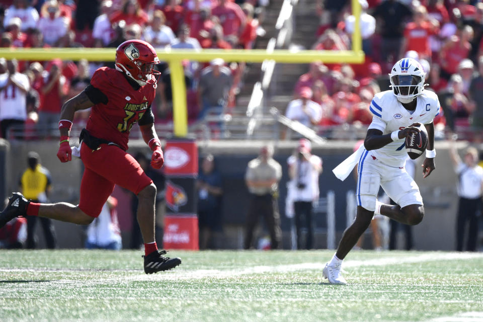 CORRECTION - Fixes players Identities. SMU quarterback Kevin Jennings runs from the pursuit from Louisville defensive back Jaden Minkins (33) during the second half of an NCAA college football game in Louisville, Ky., Saturday, Oct. 5, 2024.(AP Photo/Timothy D. Easley)