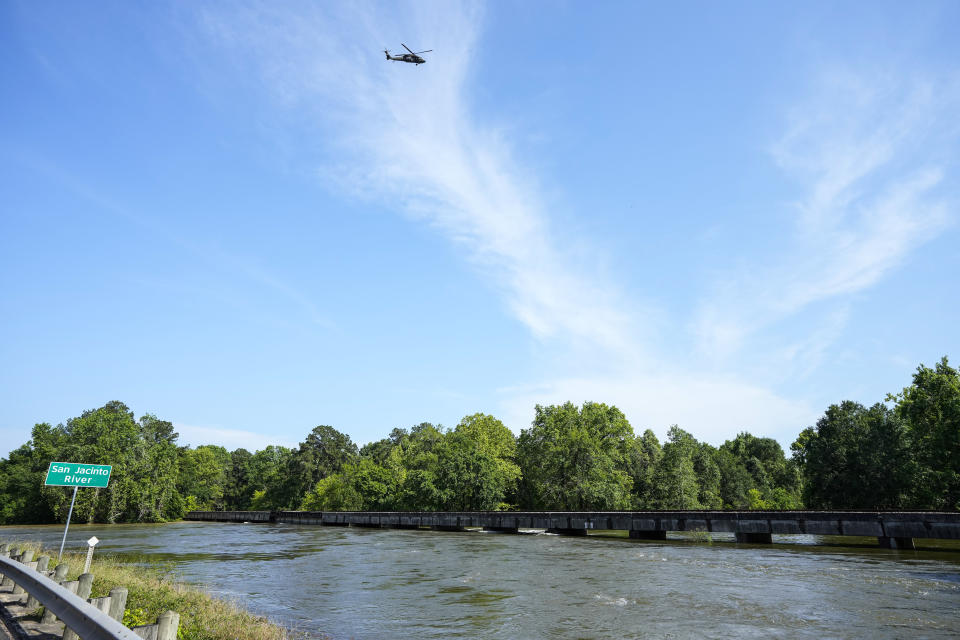 A helicopter flies above the San Jacinto River, which rose out of its banks in the aftermath of a severe storm, Thursday, May 2, 2024, in Conroe, Texas. (Brett Coomer/Houston Chronicle via AP)