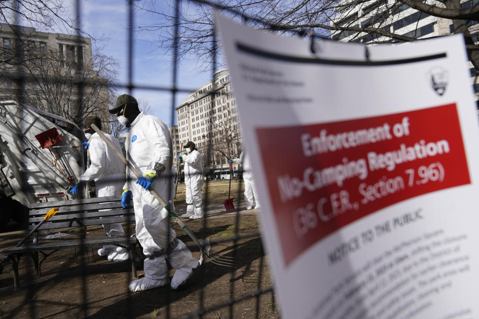 Workers clear a homeless encampment at McPherson Square in Washington, Wednesday, Feb. 15, 2023. (AP Photo/Patrick Semansky)