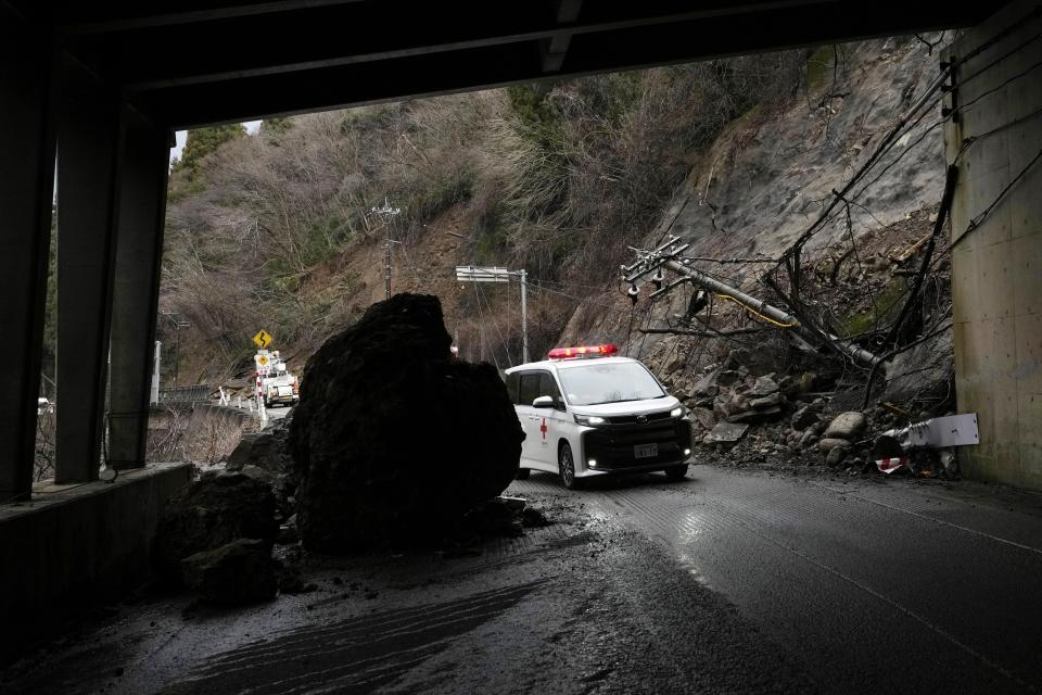 Ambulances move through fallen rocks and landslides that hit the road in Wajima in the Noto peninsula, facing the Sea of Japan, northwest of Tokyo, Saturday, Jan. 6, 2024, following Monday's deadly earthquake. (AP Photo/Hiro Komae)