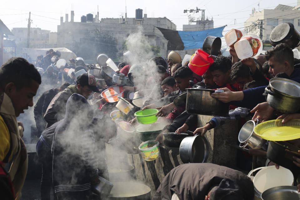 Palestinians line up for free food during the ongoing Israeli air and ground offensive on the Gaza Strip in Rafah, Tuesday, Jan. 9, 2024. (AP Photo/Hatem Ali)