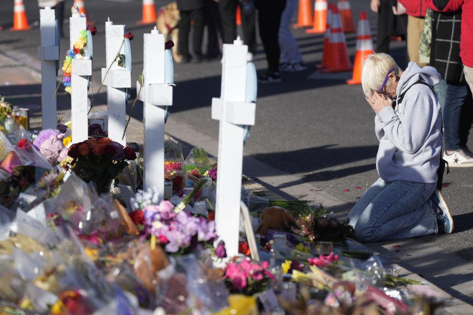 Dallas Dutka of Broomfield, Colo., prays by a makeshift memorial, Tuesday Nov. 22, 2022, for the victims of a mass shooting at a gay nightclub in Colorado Springs, Colo. Dutka's cousin, Daniel Aston, was killed in the shooting. (AP Photo/David Zalubowski)