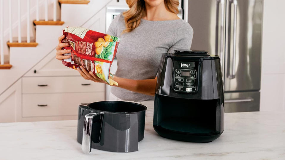 Woman cooks food in ninja AF101 air fryer