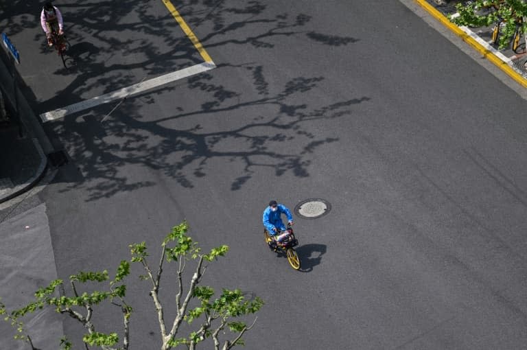 Un homme portant des vêtements de protection dans une rue de Shanghai le 18 avril 2022 - Hector RETAMAL © 2019 AFP