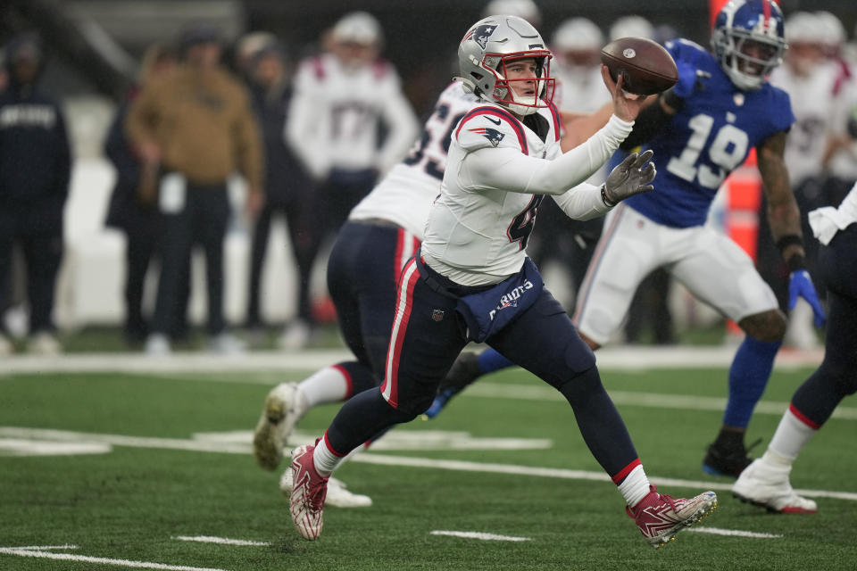 New England Patriots quarterback Bailey Zappe (4) shoves a lateral pass against the New York Giants during the third quarter of an NFL football game, Sunday, Nov. 26, 2023, in East Rutherford, N.J. (AP Photo/Seth Wenig)