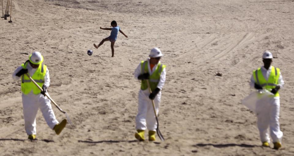 Workers continue cleaning the beach.