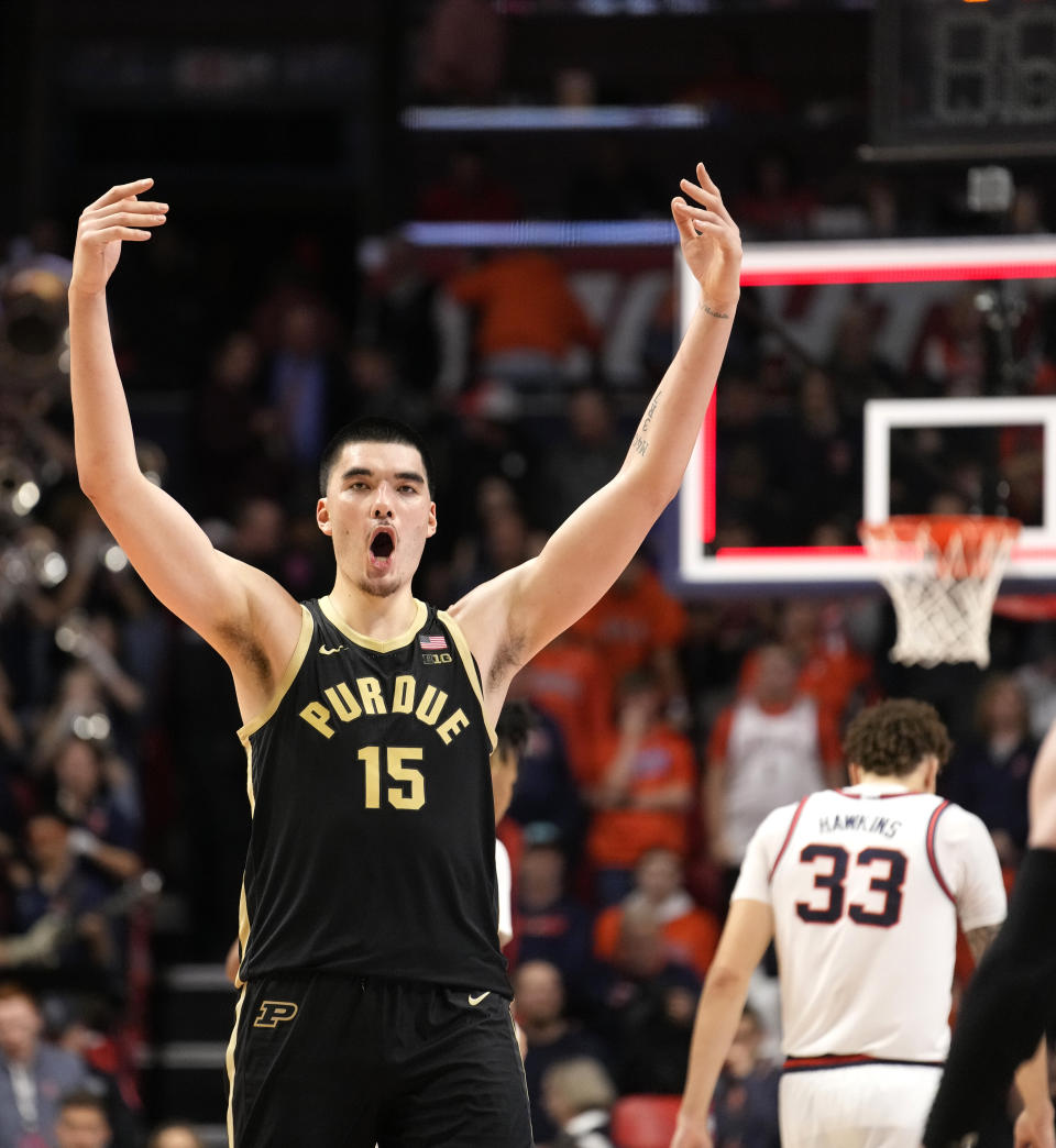 Purdue's Zach Edey (15) celebrates the team's 77-71 win over Illinois, while Illinois' Coleman Hawkins (33) walks off the court after an NCAA college basketball game Tuesday, March 5, 2024, in Champaign, Ill. (AP Photo/Charles Rex Arbogast)