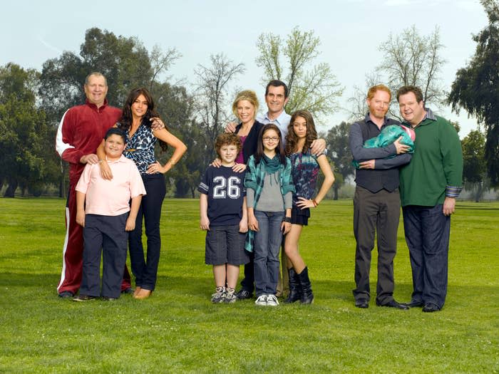 The cast of "Modern Family" standing outside in the grass