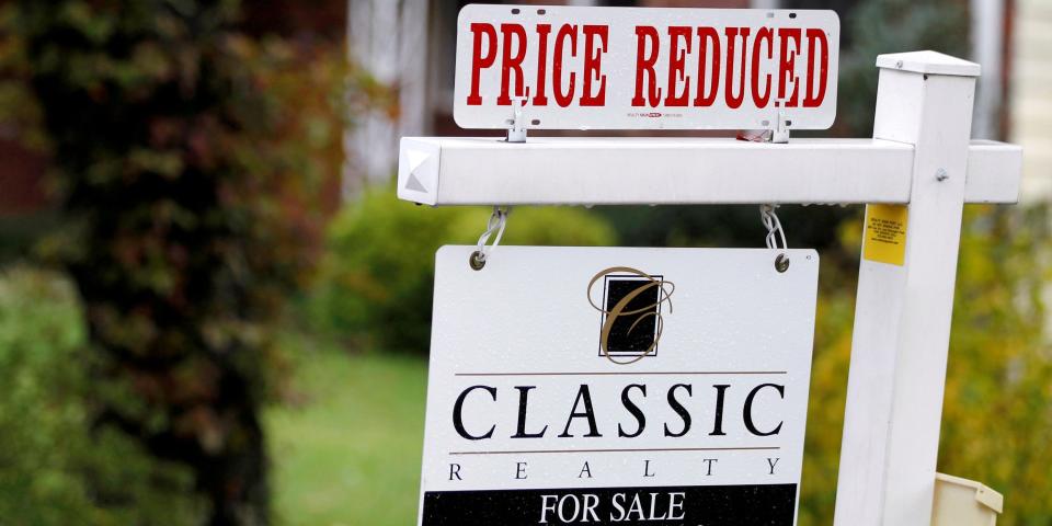 A home for sale with a price reduction sign