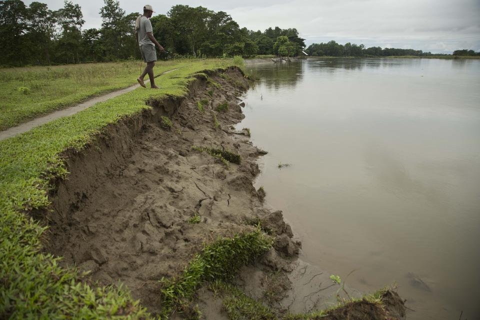 In this Wednesday, Aug. 8, 2018 photo, a man walks on the banks of the river Brahmaputra in Majuli, in the northeastern Indian state of Assam. Majuli is said to be one of the largest river islands in the world, surrounded by the fast-moving waters of the massive, though braided, Brahmaputra river. Official estimates based on satellite data show that Majuli’s land mass decreased by more than 31 per cent between 1914 and 2004. (AP Photo/Anupam Nath)