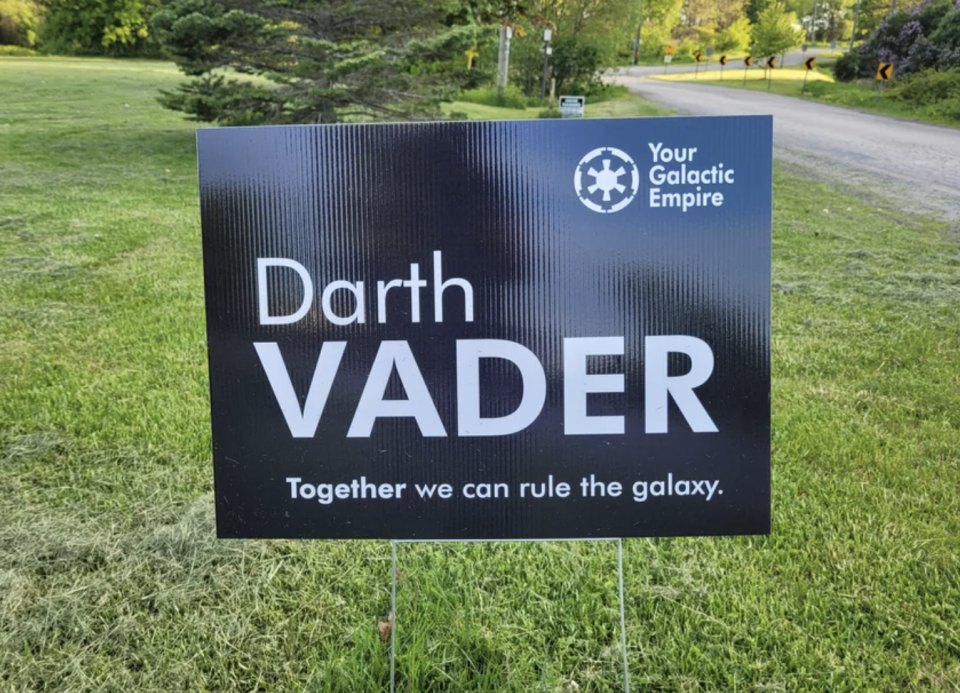 Sign with "Darth Vader - Together we can rule the galaxy" alongside the logo "Your Galactic Empire" on grass