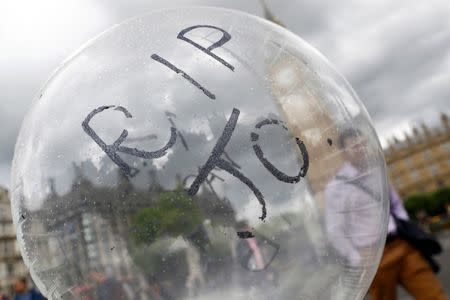 A man is seen trough a balloon in memory of murdered Labour Party MP Jo Cox, who was shot dead in Birstall, at Parliament Square in London, Britain June 20, 2016. REUTERS/Stefan Wermuth