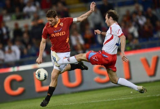 AS Roma's forward Francesco Totti (L) fights for the ball with a Catania player during an Italian Serie A football match at Rome's Olympic stadium. Roma all but crashed out of European contention with a limp performance in a 2-2 draw at home to Catania