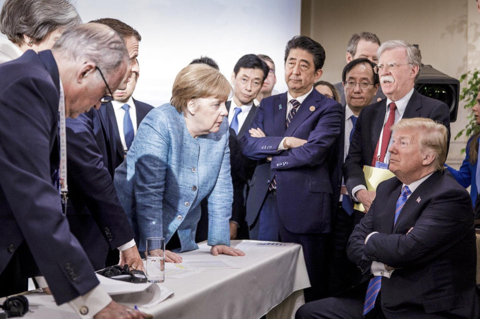 FILE - In this photo made available by the German Federal Government, German Chancellor Angela Merkel, center, speaks with U.S. President Donald Trump, seated at right, during the G7 Leaders Summit in La Malbaie, Quebec, Canada, June 9, 2018. Merkel has been credited with raising Germany’s profile and influence, helping hold a fractious European Union together, managing a string of crises and being a role model for women in a near-record tenure. Her designated successor, Olaf Scholz, is expected to take office Wednesday, Dec. 8, 2021. (Jesco Denzel/German Federal Government via AP)