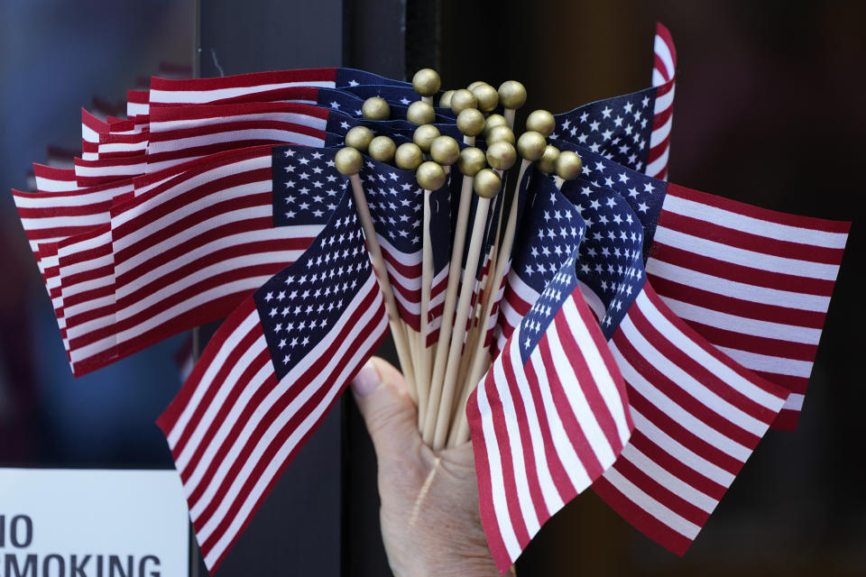 A volunteer holds flags during U.S. Sen. Joni Ernst's Roast and Ride, Saturday, June 3, 2023, in Des Moines, Iowa. (AP Photo/Charlie Neibergall)