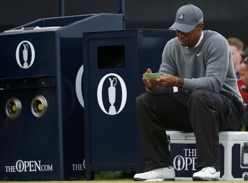 Tiger Woods of the U.S. marks his card as he sits on the 17th tee during the first round of the British Open golf championship on the Old Course in St. Andrews, Scotland, July 16, 2015. REUTERS/Lee Smith