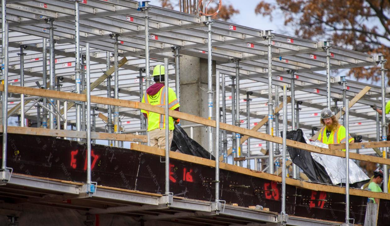 Construction crews lay down a tarp as they work on building the Ferguson International Center on the Indiana University campus on Thursday, Dec. 2, 2021.