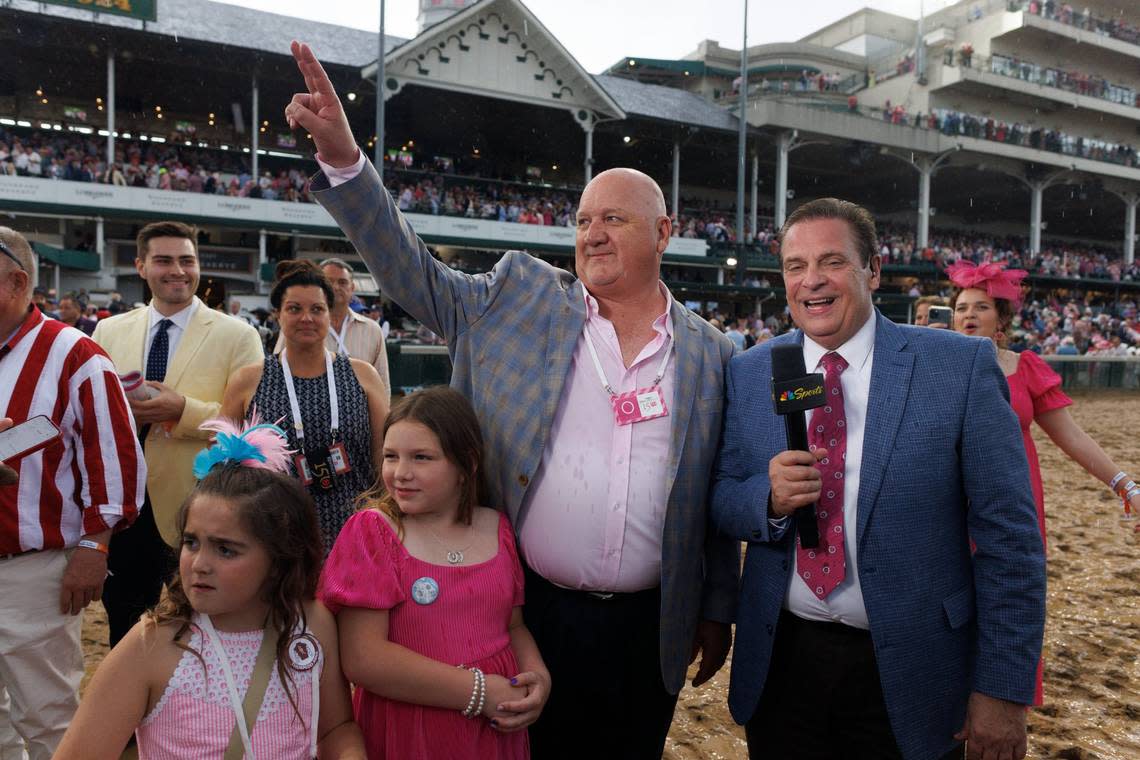 Trainer Kenny McPeek waves to the crowd before being interviewed by NBC’s Kenny Rice after winning the Kentucky Oaks with Thorpedo Anna on Friday. McPeek had never won the race in 14 previous attempts, including three second-place finishes. Jonathan Palmer
