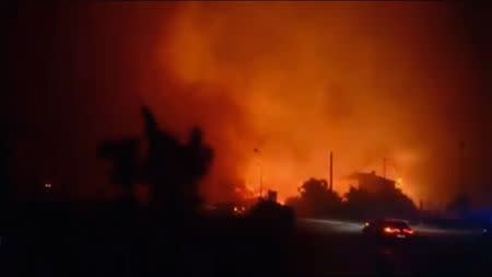 Cars drive past forest fires in Biguglia, near the town of Bastia, on Corsica island, France, July 24, 2017 in this still image from a video obtained from social media. Facebook/Florianne Amblard via REUTERS