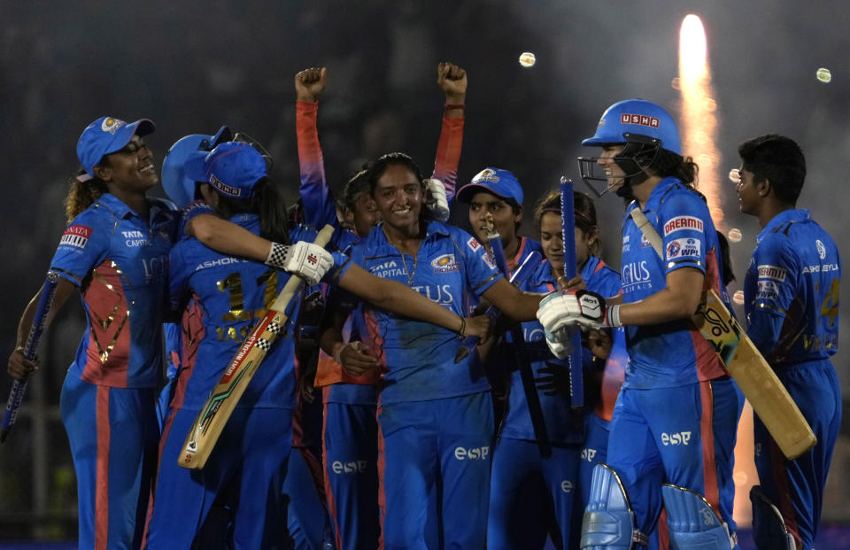 Mumbai Indians captain Harmanpreet Kaur, centre without cap, celebrates with teammates their win in the Women's Premier League Twenty20 cricket final match against Delhi Captials in Mumbai, India, Sunday, March 26, 2023. (AP Photo/Rajanish Kakade)