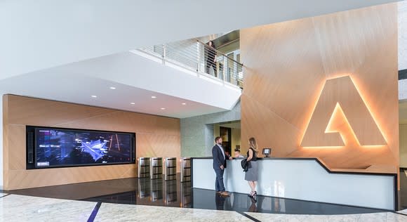 Adobe headquarters front desk with lit-up Adobe logo behind it