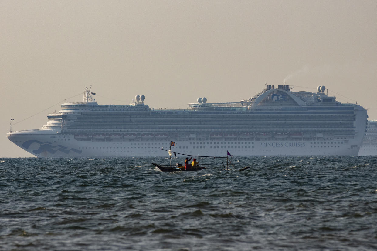 FILE PHOTO: A small fishing boat passes by the cruise ship, Ruby Princess on May 7, 2020 in the waters of Manila Bay, Philippines. The Ruby Princess cruise ship, which is linked to 21 deaths and more than 600 coronavirus (COVID-19) cases, has sailed into Philippine waters on Thursday en route to drop off Filipino crew in Manila. The cruise ship, which is the subject of investigation in Australia, joins at least 16 other cruise ships at anchor waiting for their more than 5,000 Filipino crew to be tested for the coronavirus before disembarking as part of strict quarantine protocols. (Photo by Ezra Acayan/Getty Images)