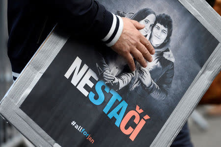 FILE PHOTO: A man attends a protest rally in reaction to the murder of Slovak investigative reporter Jan Kuciak and his fiancee Martina Kusnirova, in Bratislava, Slovakia April 5, 2018. The placard shows portraits of Jan Kuciak and Martina Kusnirova and reads "Not enough". REUTERS/Radovan Stoklasa