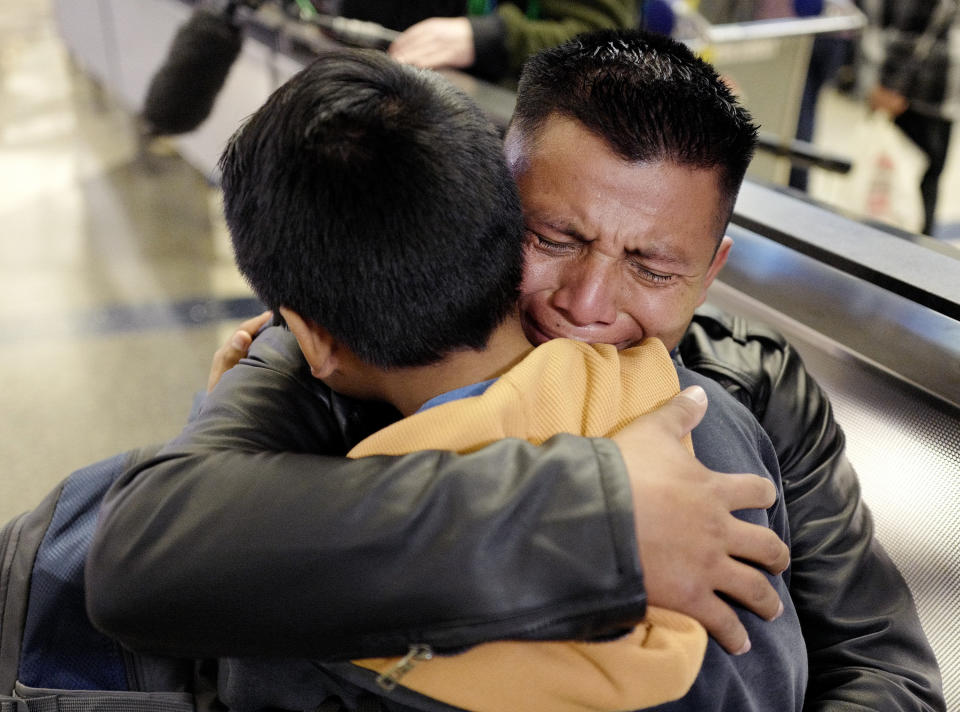 FILE - In this Wednesday, Jan. 22, 2020, file photo, David Xol-Cholom, of Guatemala, hugs his son Byron at Los Angeles International Airport as they reunite after being separated during the Trump administration's wide-scale separation of immigrant families, in Los Angeles. A court-appointed committee has yet to find the parents of 628 children separated at the border early in the Trump administration. (AP Photo/Ringo H.W. Chiu, File)