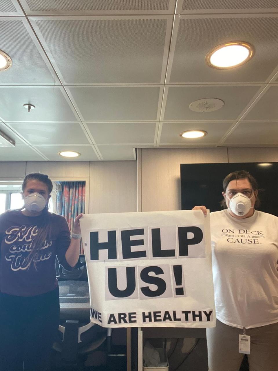 American crew member Melinda Mann (right) is seen protesting her detainment on the MS Oosterdam with a colleague.