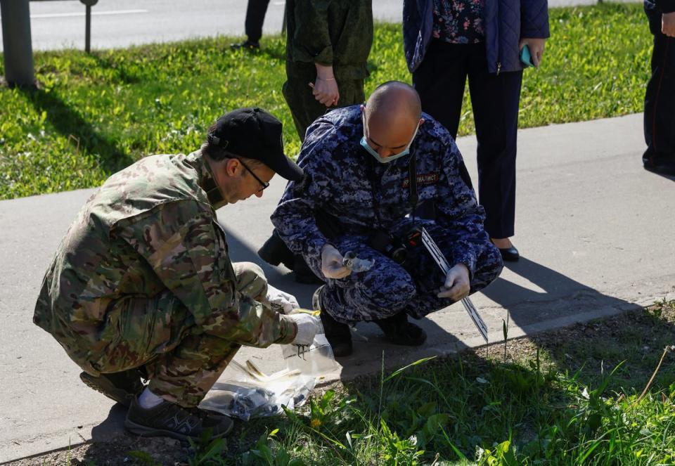 Investigators gather evidence while working outside a damaged multi-storey apartment block following a reported drone attack in Moscow, Russia (REUTERS)