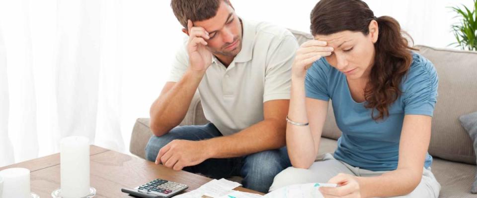 Worried couple doing their accounts in the living room at home