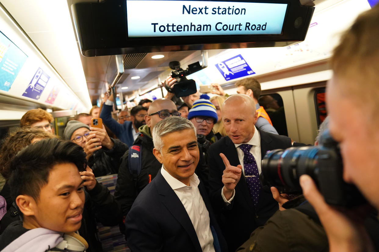 Mayor of London Sadiq Khan (centre) and Andy Byford, Commissioner at Transport for London (Tfl) (right) pose for photographers as they journey aboard the first Elizabeth line train to carry passengers as it approaches Tottenham Court Road Station, London. The delayed and overbudget line will boost capacity and cut journey times for east-west travel across the capital. Picture date: Tuesday May 24, 2022.