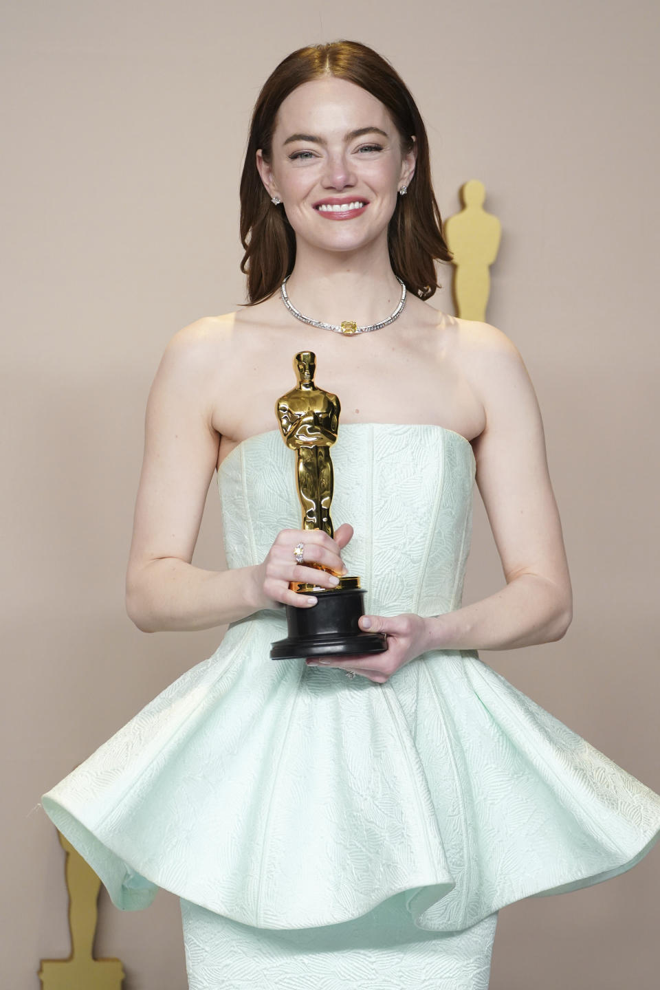 Emma Stone poses in the press room with the award for best performance by an actress in a leading role for "Poor Things" at the Oscars on Sunday, March 10, 2024, at the Dolby Theatre in Los Angeles. (Photo by Jordan Strauss/Invision/AP)